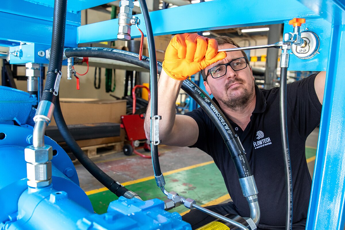 Flowtech engineer servicing blue hydraulic power pack